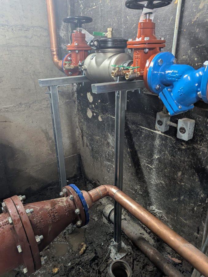 Commercial backflow preventer assembly installed on copper piping in a mechanical room